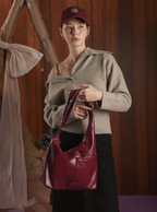 Woman carrying the Midi Arc slouchy hobo bag in wine red vegan leather for work, travel and everyday use