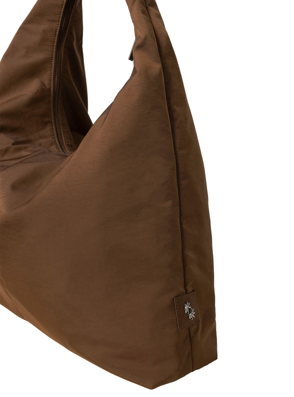 Close-up of the Arc hobo-style bag in chocolate brown nylon, showing metal logo emblem