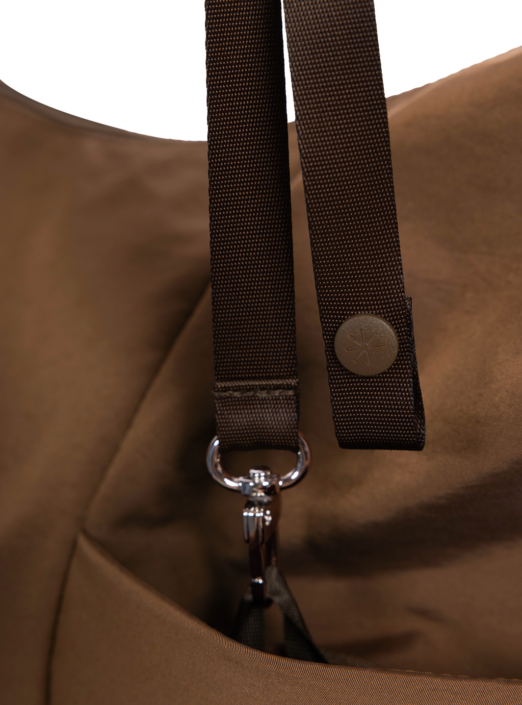 Exterior pocket of the Arc hobo-style bag in chocolate brown nylon with concealed snap loop