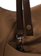 Exterior pocket of the Arc hobo-style bag in chocolate brown nylon with concealed snap loop