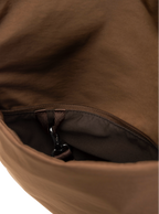 Exterior pocket of the Arc hobo-style bag in chocolate brown nylon with concealed snap loop