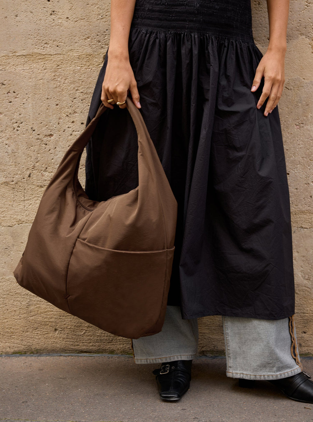 Woman carrying The Arc slouchy roomy hobo-style bag in chocolate brown nylon for everyday use