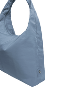 Close-up of the Arc hobo-style bag in grey blue nylon, showing metal logo emblem
