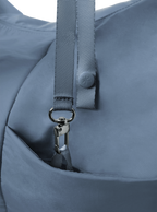 Exterior pocket of the Arc hobo-style bag in grey blue nylon, with concealed snap loop