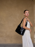 Woman carrying the Midi Arc slouchy hobo bag in black vegan leather as shoulder bag