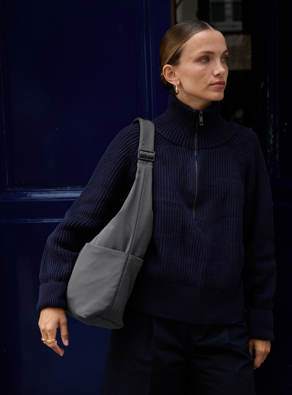 Woman carrying the Midi Arc slouchy hobo bag in dark grey nylon as shoulder bag