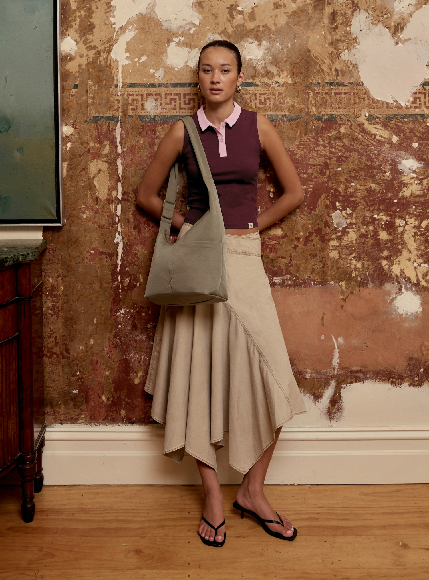 Woman carrying the Midi Arc slouchy hobo-style bag in beige nylon as shoulder bag for work, travel and everyday use