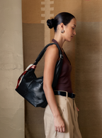 Woman carrying the Midi Arc slouchy hobo bag in matte black vegan leather as shoulder bag