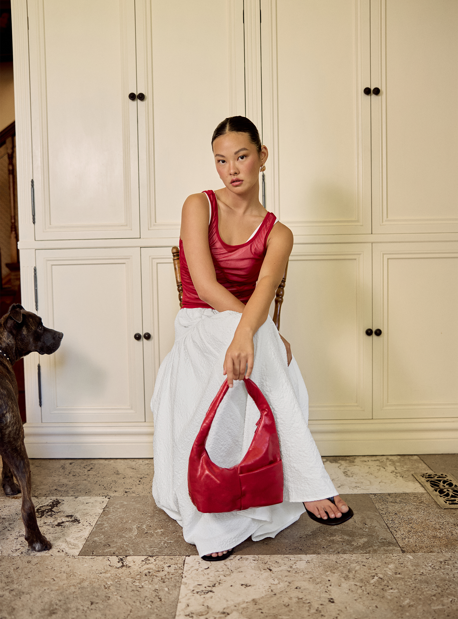 Woman holding the Mini Arc slouchy hobo-style shoulder bag in red vegan leather for errands, weekends and everyday use