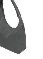 Close-up of the Midi Arc hobo-style bag in dark grey nylon, showing metal logo emblem