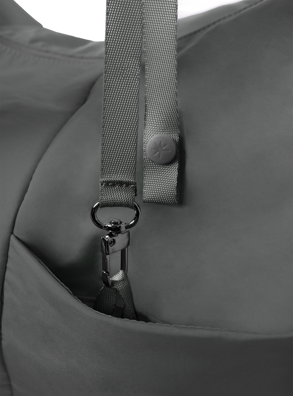 Exterior pocket of the Midi Arc hobo-style bag in dark grey nylon, with concealed snap loop