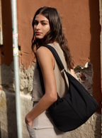 Woman carrying the Midi Arc slouchy hobo bag in black nylon as shoulder bag