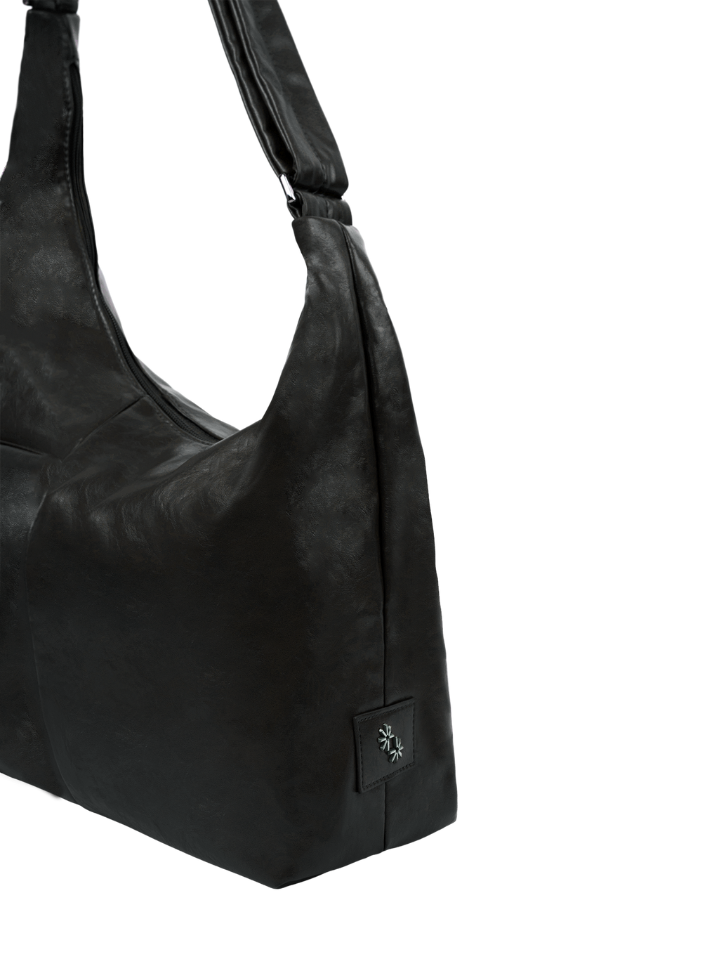 Close-up of the Midi Arc hobo-style bag in matte black vegan leather, showing metal logo emblem