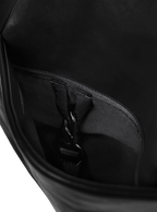 Exterior pocket of the Midi Arc hobo-style bag in matte black vegan leather, with concealed snap loop