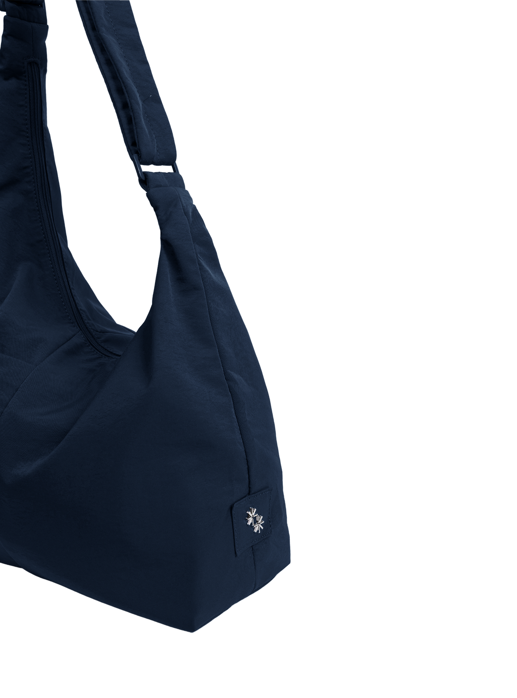 Close-up of the Midi Arc hobo-style bag in navy nylon, showing metal logo emblem