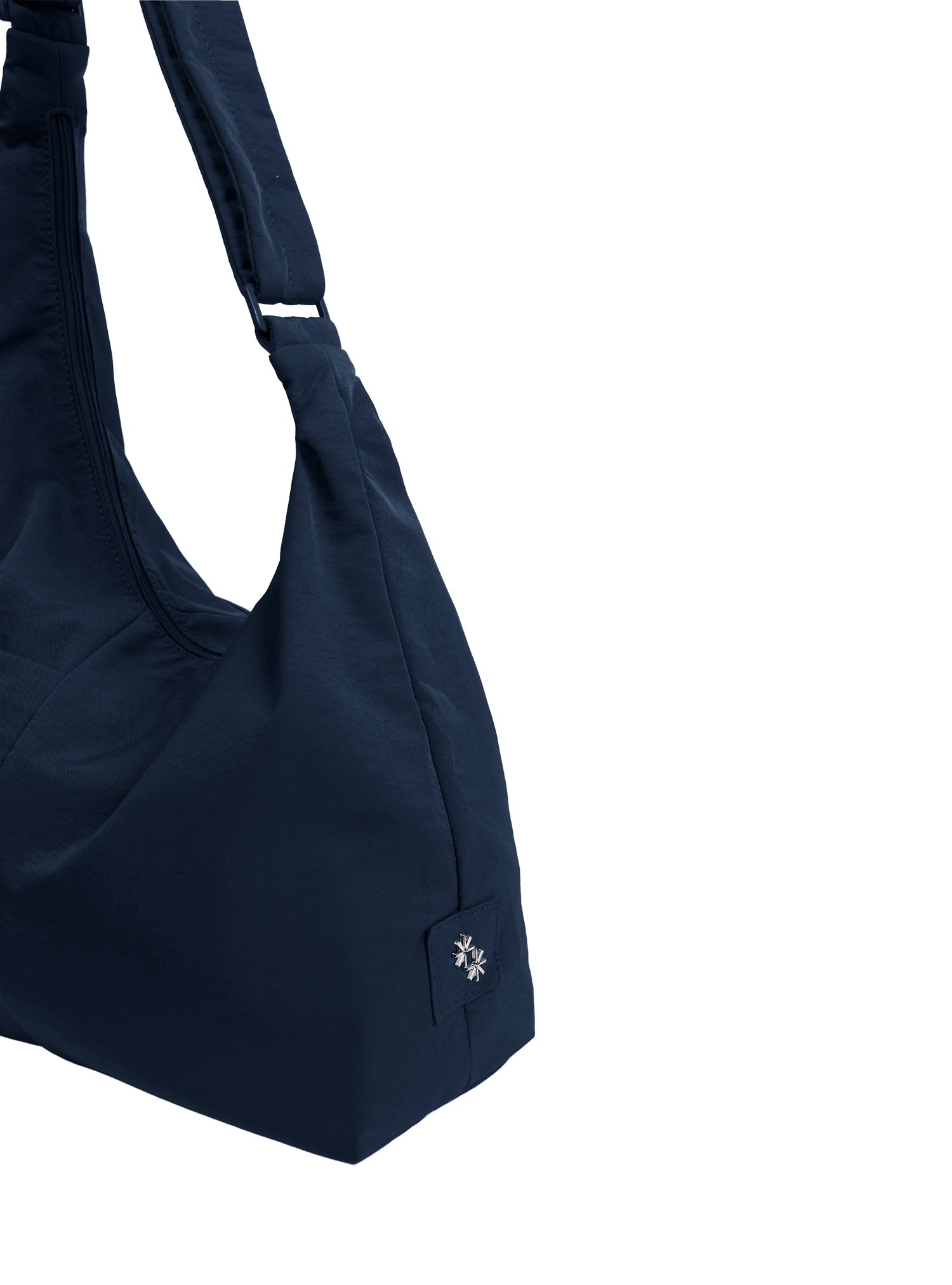 Close-up of the Midi Arc hobo-style bag in navy nylon, showing metal logo emblem