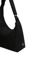Close-up of the Midi Arc hobo-style bag in black nylon, showing metal logo emblem