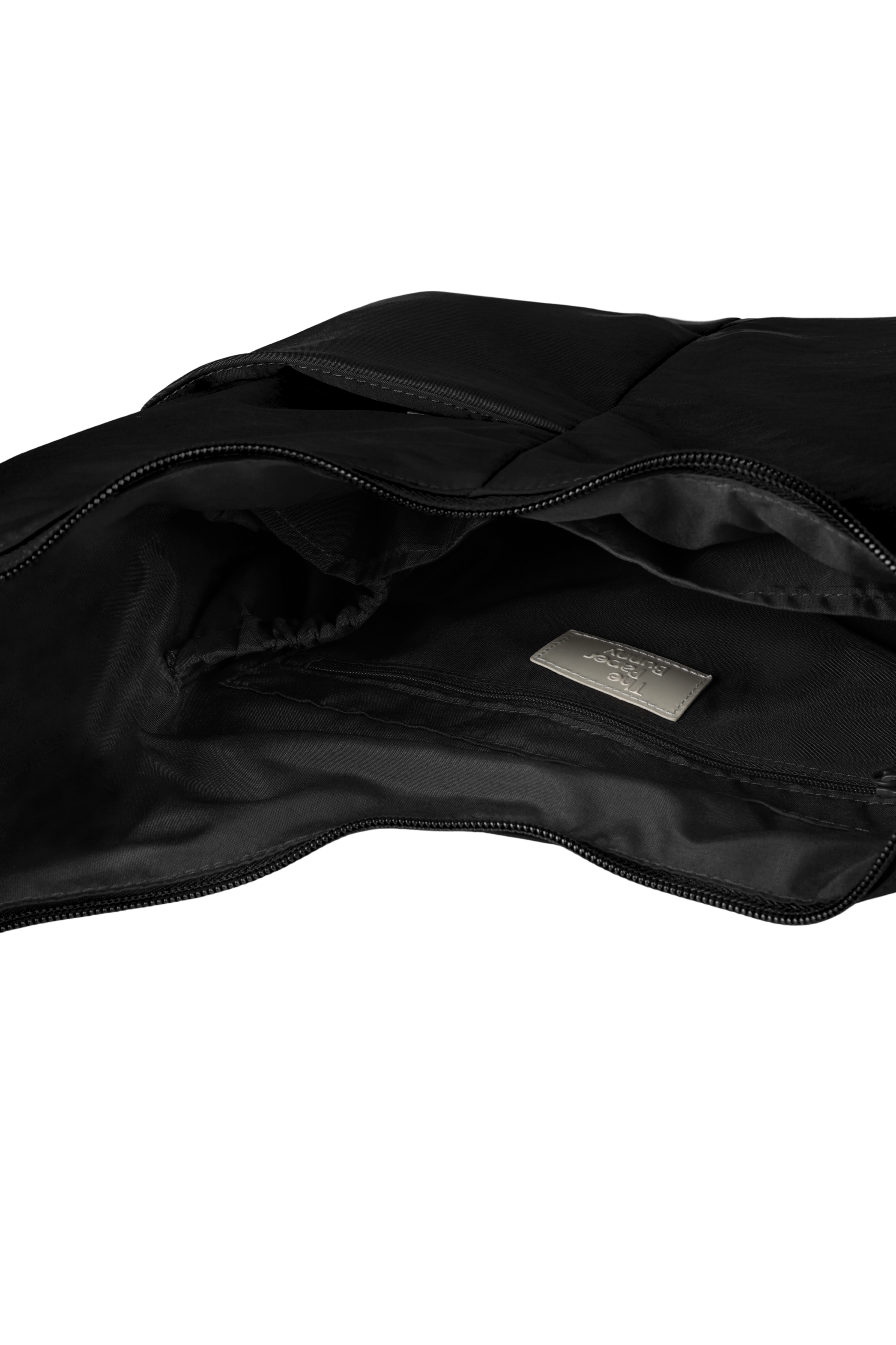 Interior of the Midi Arc hobo-style bag in black nylon, with multiple pockets and a bottle holder