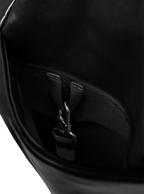 Exterior pocket of the Midi Arc hobo-style bag in black vegan leather, with concealed snap loop
