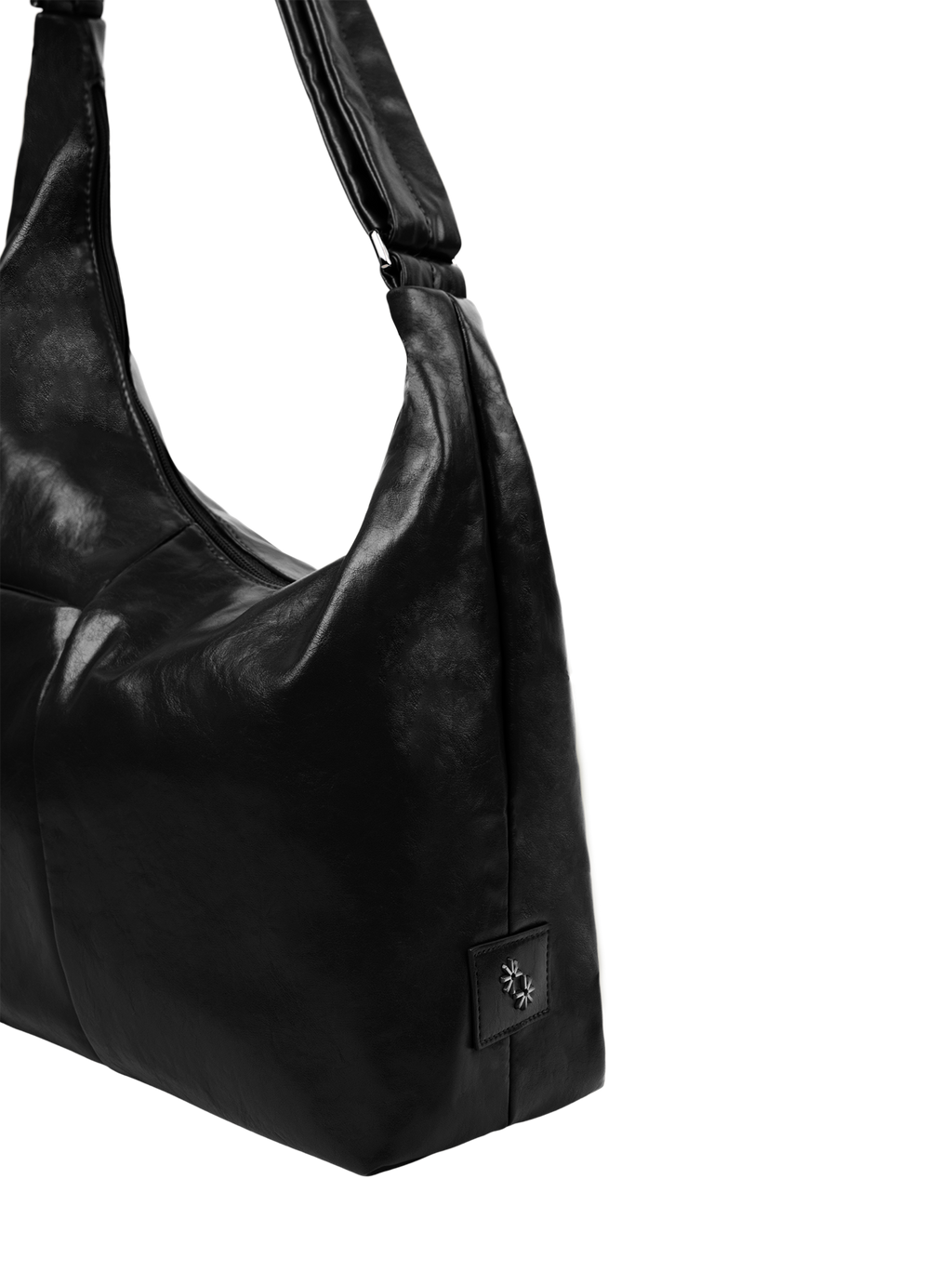 Close-up of the Midi Arc hobo-style bag in black vegan leather, showing metal logo emblem