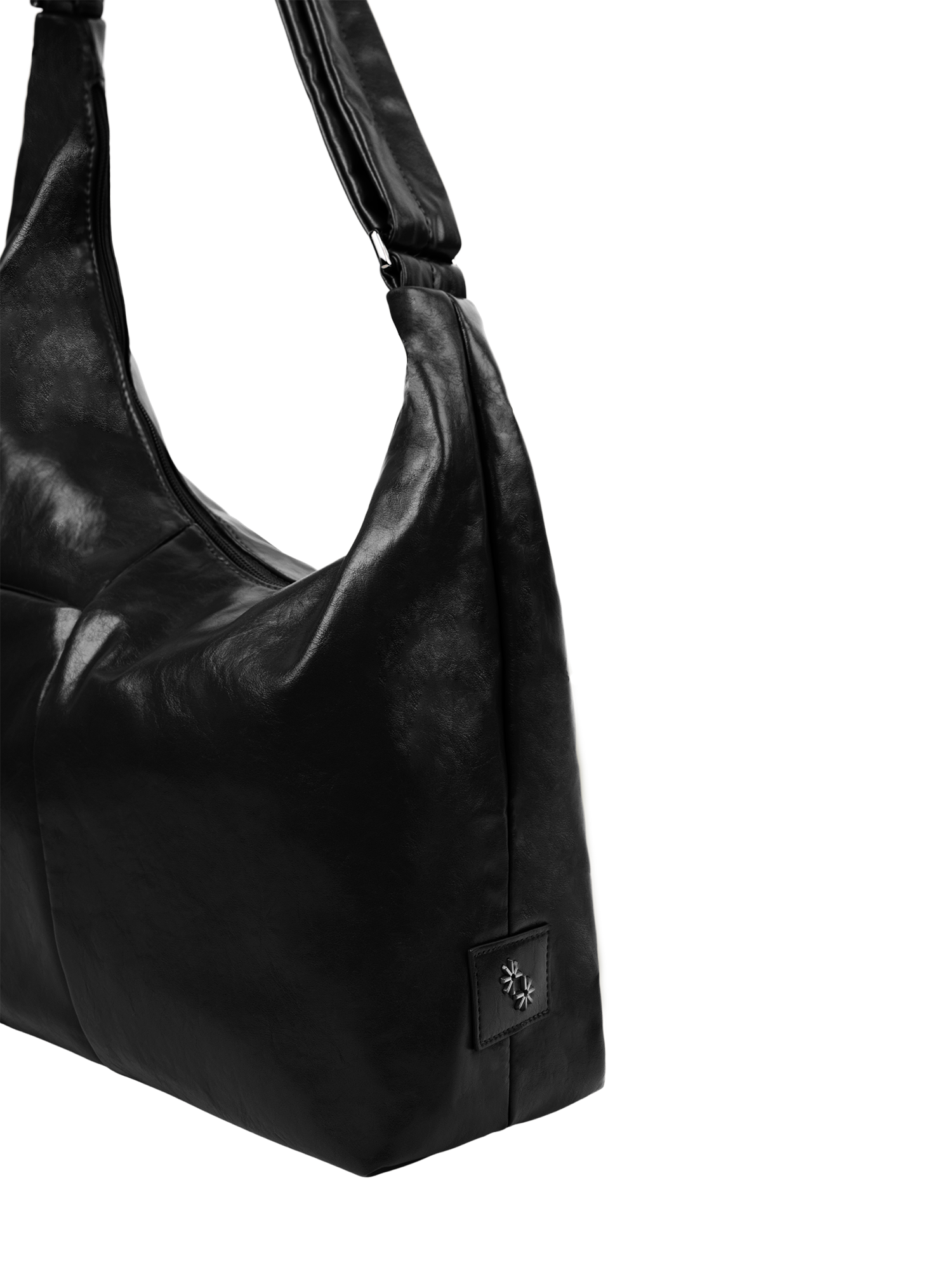 Close-up of the Midi Arc hobo-style bag in black vegan leather, showing metal logo emblem