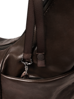 Exterior pocket of the Midi Arc hobo-style bag in dark brown vegan leather, with concealed snap loop