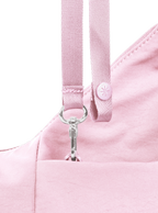 Exterior pocket of the Mini Arc hobo-style shoulder bag in light pink nylon, with concealed snap loop