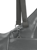 Exterior pocket of the Mini Arc hobo-style shoulder bag in deep grey vegan leather, with concealed snap loop