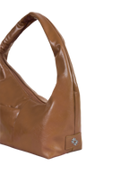 Close-up of the Mini Arc hobo-style shoulder bag in warm brown vegan leather, showing metal logo emblem