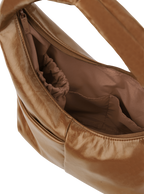 Interior of the Mini Arc hobo-style shoulder bag in warm brown vegan leather, with multiple pockets and a bottle holder
