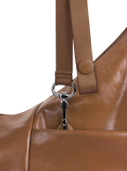Exterior pocket of the Mini Arc hobo-style shoulder bag in warm brown vegan leather, with concealed snap loop