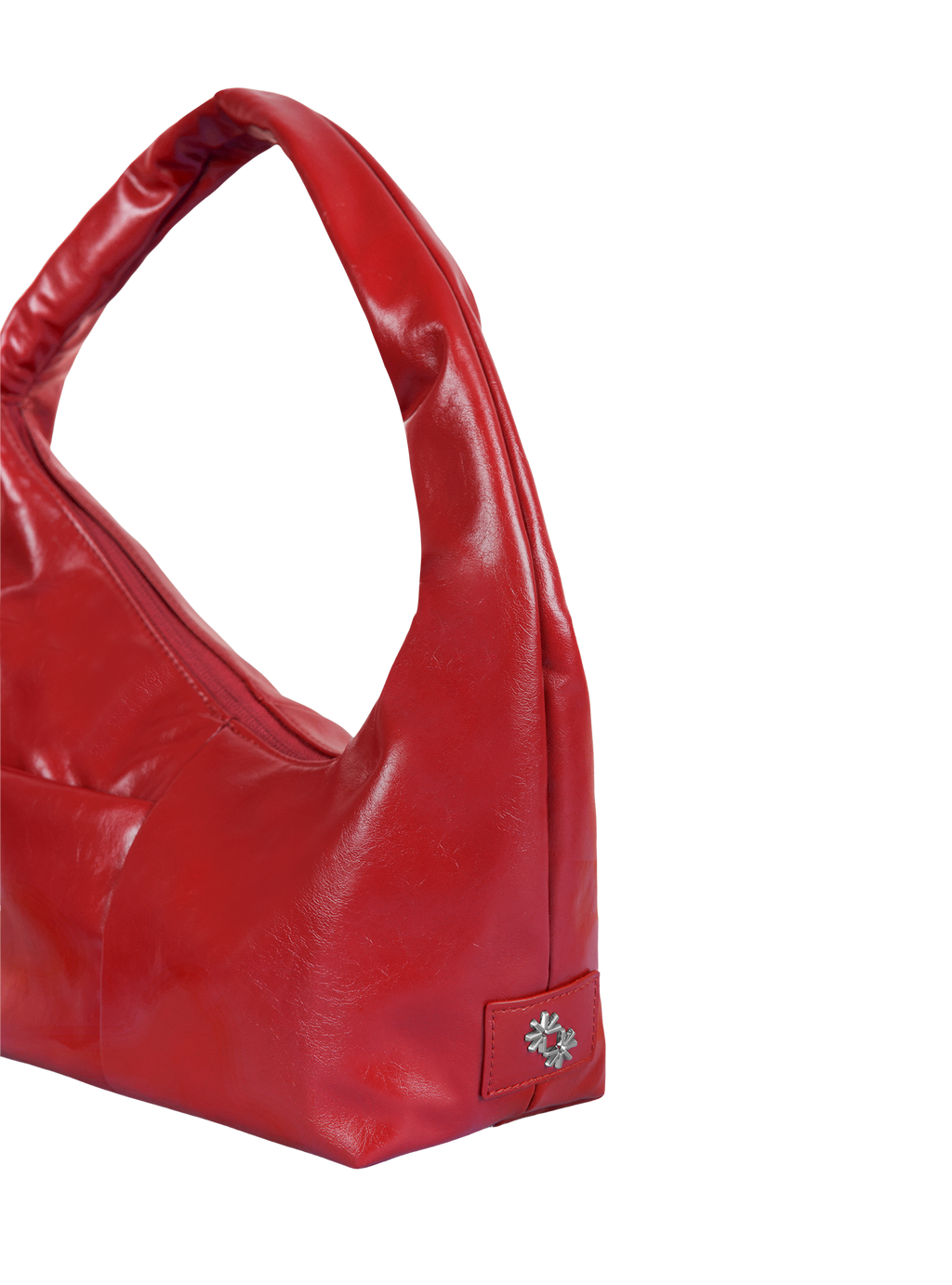 Close-up of the Mini Arc hobo-style shoulder bag in red vegan leather, showing metal logo emblem