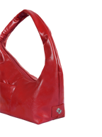 Close-up of the Mini Arc hobo-style shoulder bag in red vegan leather, showing metal logo emblem