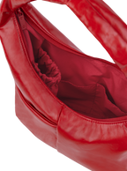 Interior of the Mini Arc hobo-style shoulder bag in red vegan leather, with multiple pockets and a bottle holder