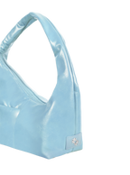 Close-up of the Mini Arc hobo-style shoulder bag in pale blue vegan leather, showing metal logo emblem