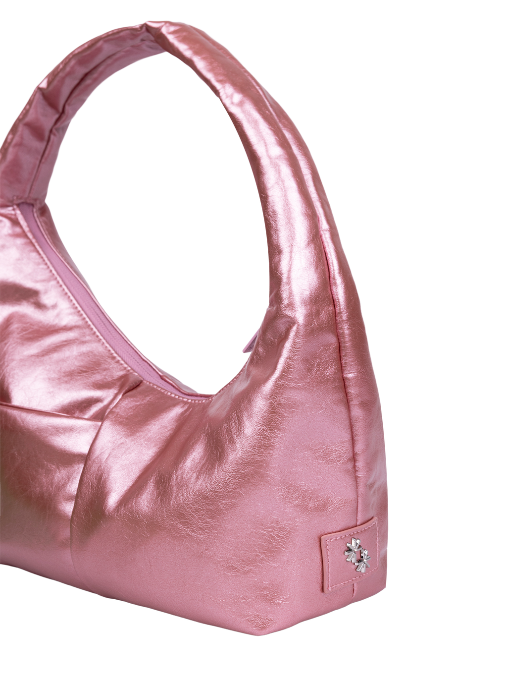 Close-up of the Mini Arc hobo-style shoulder bag in metallic pink vegan leather, showing metal logo emblem