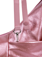 Exterior pocket of the Mini Arc hobo-style shoulder bag in metallic pink vegan leather, with concealed snap loop