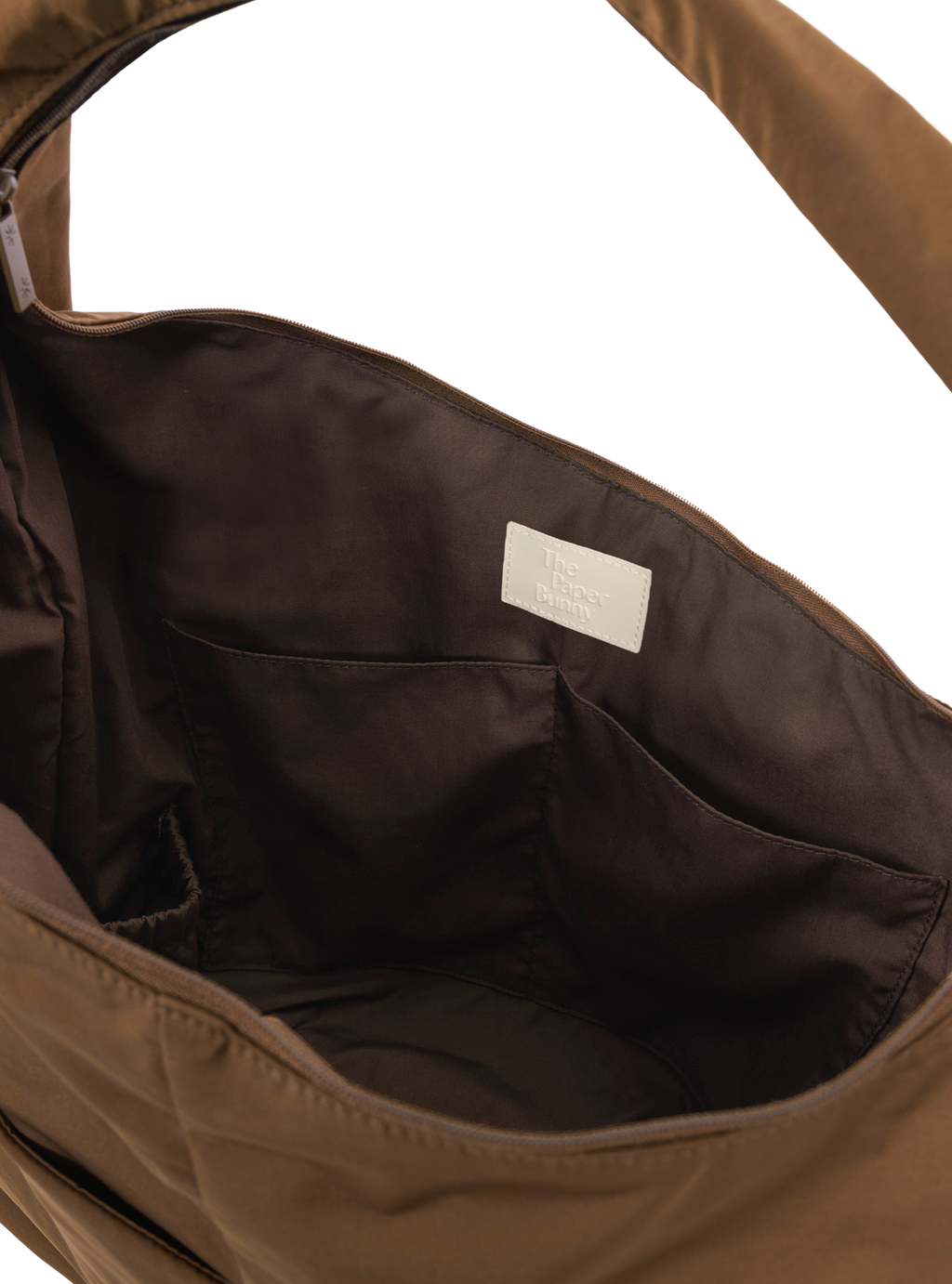 Interior of the Arc hobo-style bag in chocolate brown nylon, with multiple pockets and a bottle holder