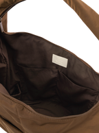 Interior of the Arc hobo-style bag in chocolate brown nylon, with multiple pockets and a bottle holder