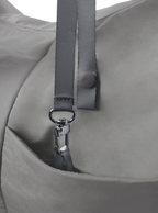 Exterior pocket of the Arc hobo-style bag in grey nylon, with concealed snap loop