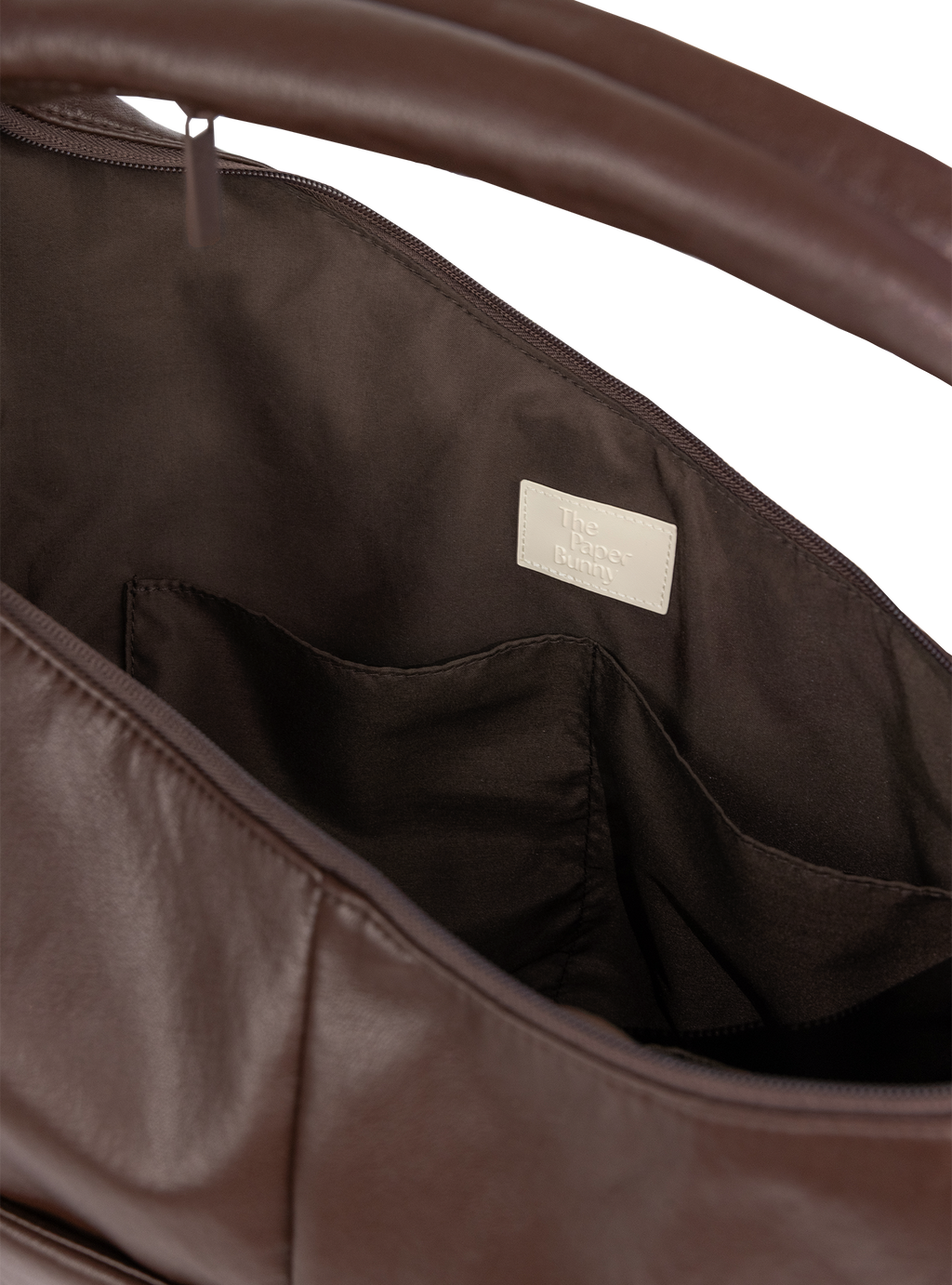 Interior of the Arc hobo-style bag in dark reddish brown matte vegan leather, with multiple pockets
