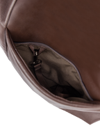 Exterior pocket of the Arc hobo-style bag in dark reddish brown matte vegan leather, with concealed snap loop